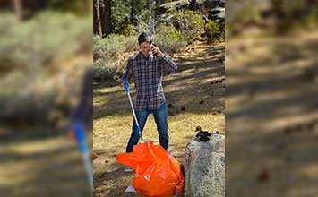 CEO Jordan Zarate picking up trash outdoors