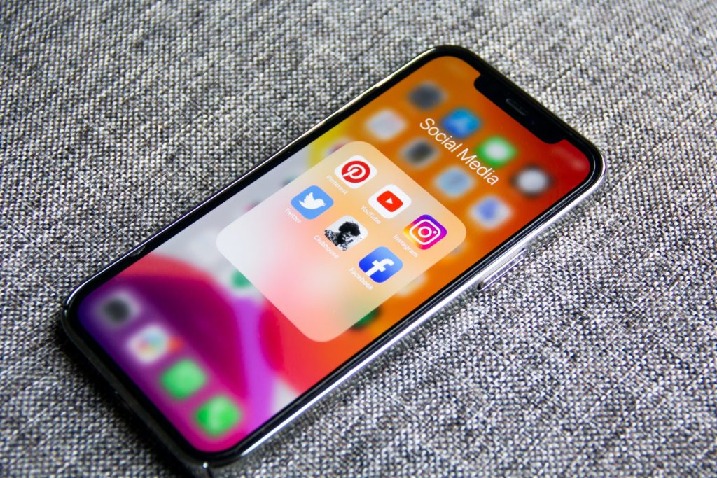 An iPhone with social media app icons on the screen