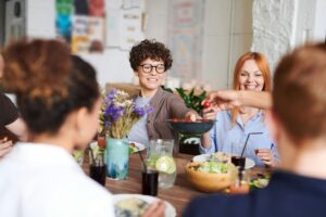 A group of people smiling and sharing a meal