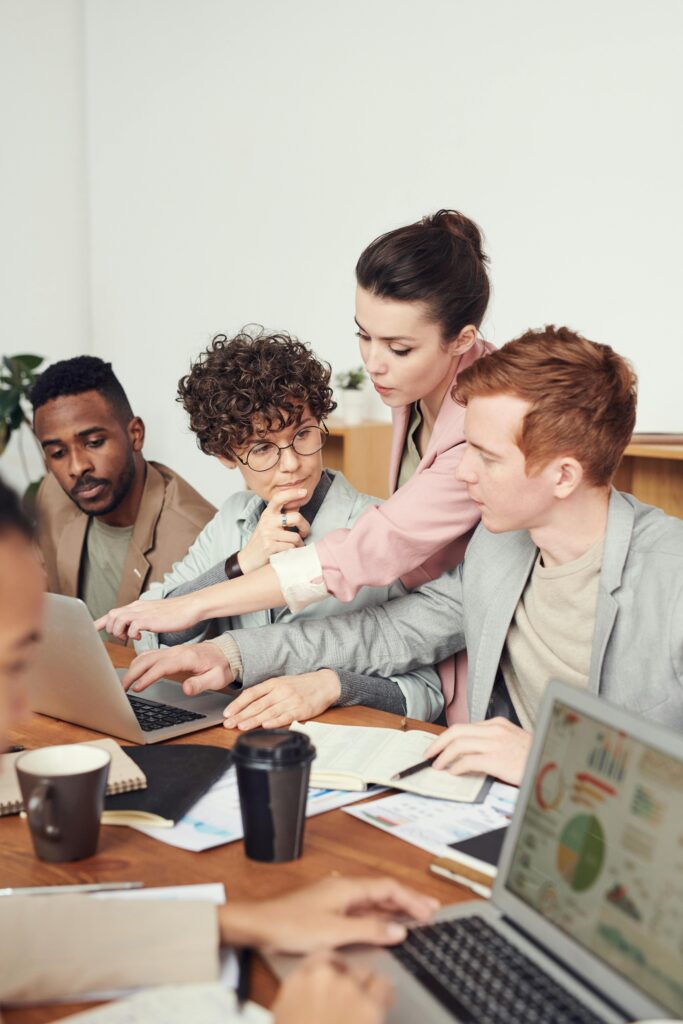 People in a meeting discussing and pointing at a computer screen