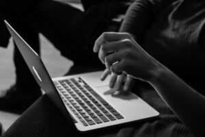 black and white photo of a person looking at their laptop